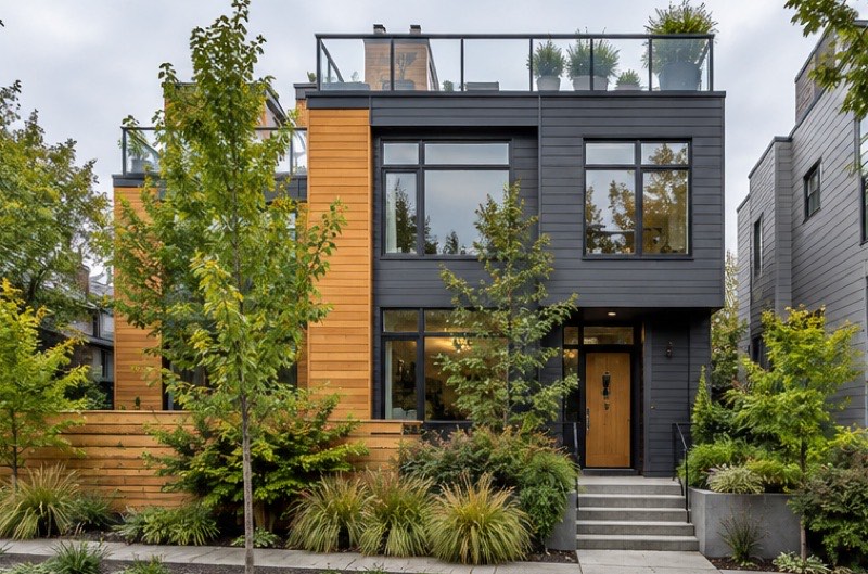 Modern three-storey Ballard townhome with charcoal and cedar siding and a glass-railed rooftop deck